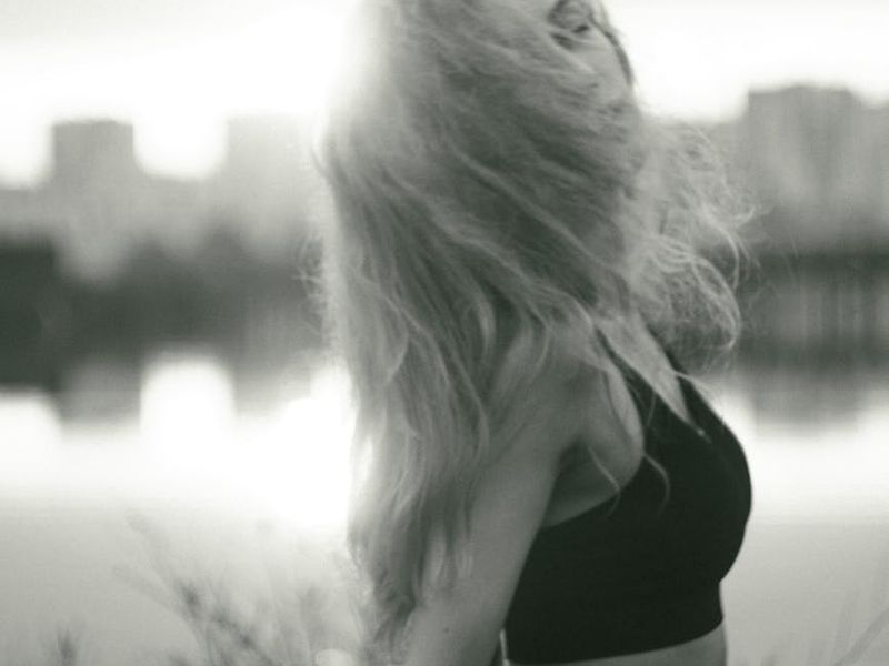 Silhouette of a woman stretching against a minimalist background